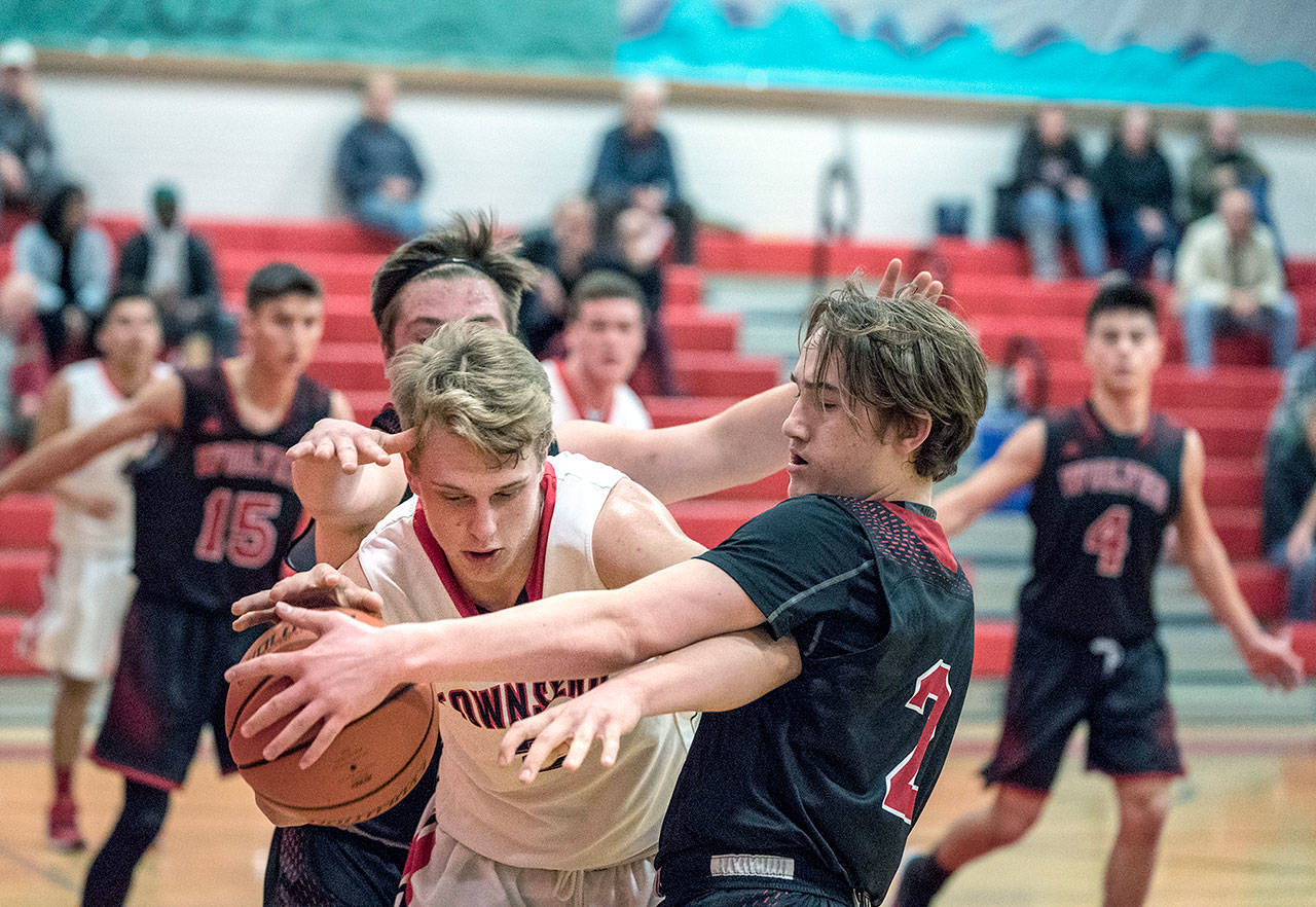 Steve Mullensky/for Peninsula Daily News Port Townsend’s Kaiden Parcher, left, duels with Coupeville’s Ethan Spark for control of the ball during the Redhawks 55-27 win Tuesday.