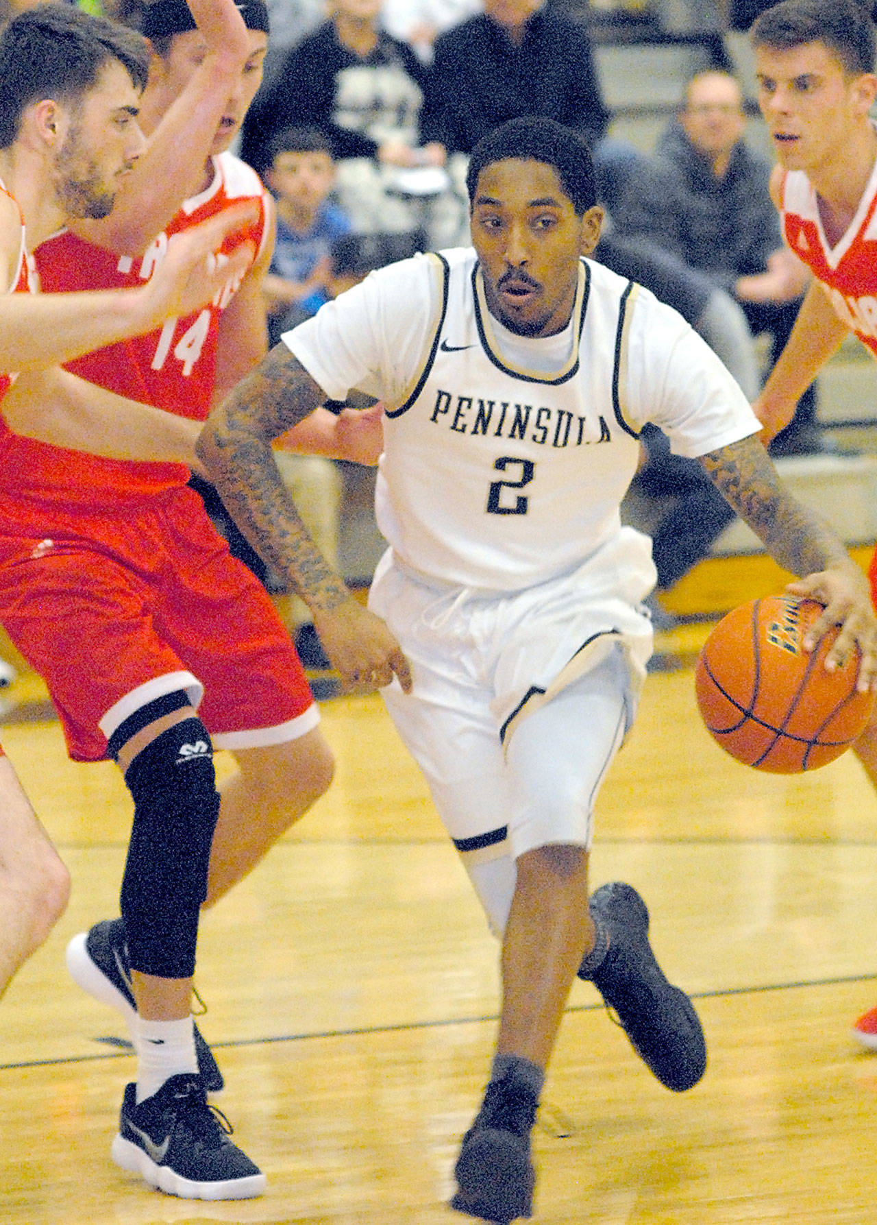 Keith Thorpe/Peninsula Daily News Peninsula’s Cameron Burton, center, drives to the lane and into the defense of Everett’s Chase Streby, left, and Conner Moffatt during first-half play on Saturday night in Port Angeles. Looking on at right is Everett’s Cameron Plautz.