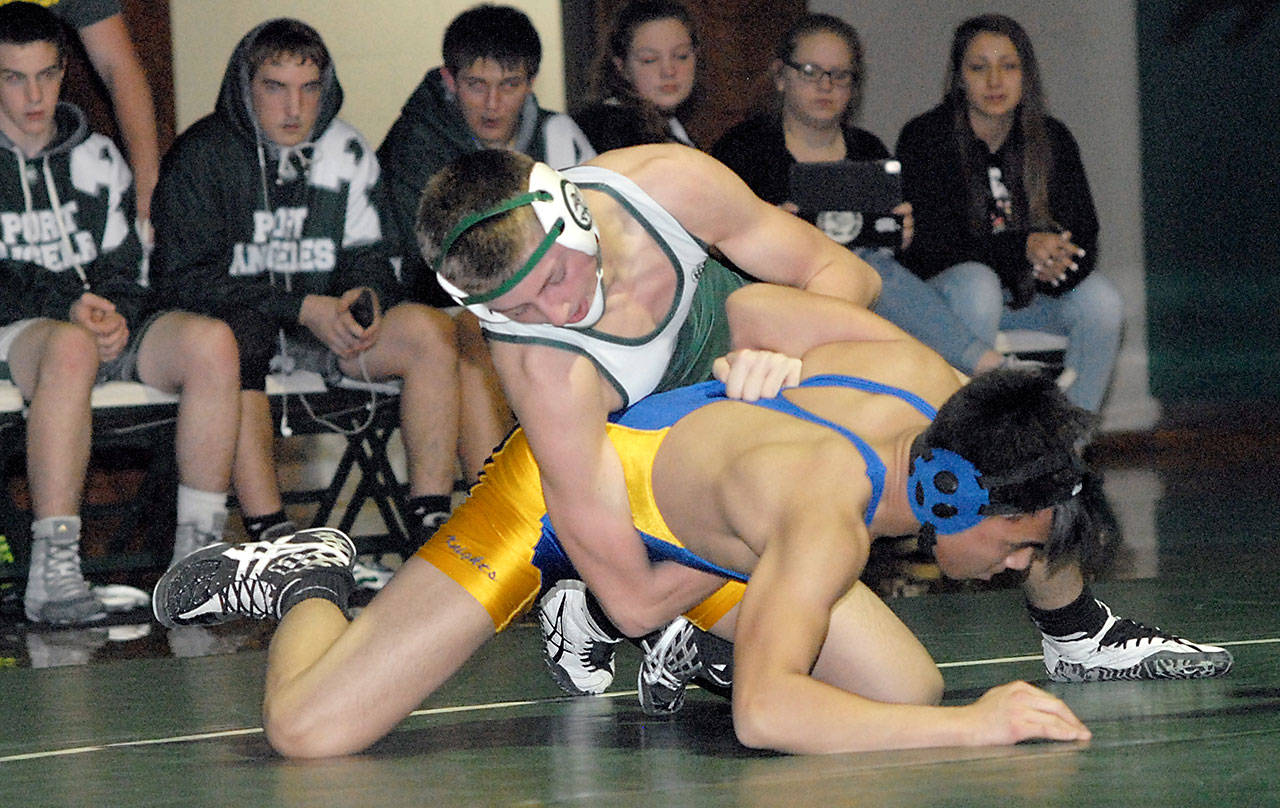 Keith Thorpe/Peninsula Daily News Port Angeles’ Grant Abrams, top, grapples with Bremerton’s Ethan Miraflor in the 145-pound weight class during Thursday’s meet at Port Angeles High School.