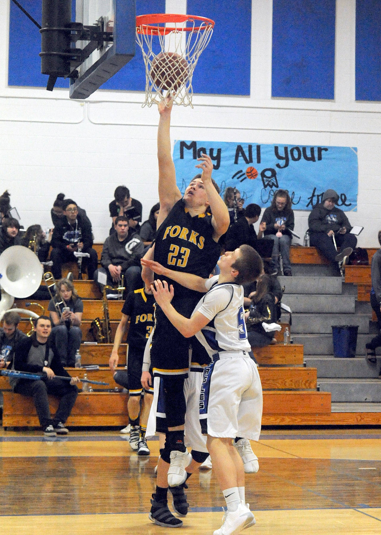 Lonnie Archibald/for Peninsula Daily News                                Forks’ Braton Armas (23) scores over Elma’s Carter Jacobson Friday night in Elma. Forks beat the Eagles 65-46 to go to 5-0 in the Evergreen 1A League.