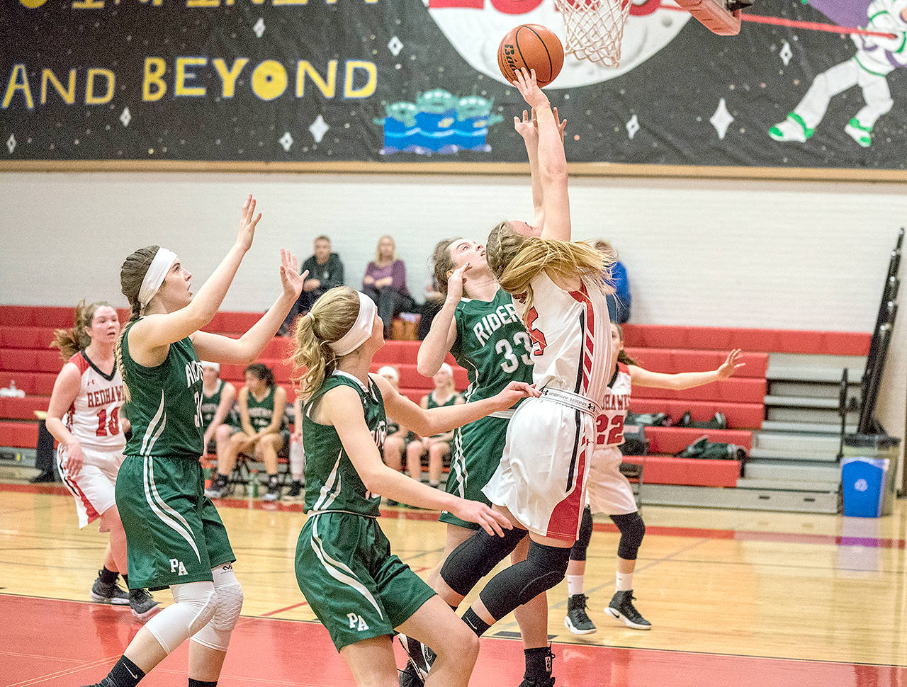 Port Townsend’s Kaitlyn Meek, right, goes up for a basket while surrounded by Port Angeles Roughriders, from left, Devin Edwards, Emilia Long and Jaida Wood.                                Steve Mullensky/for Peninsula Daily News
