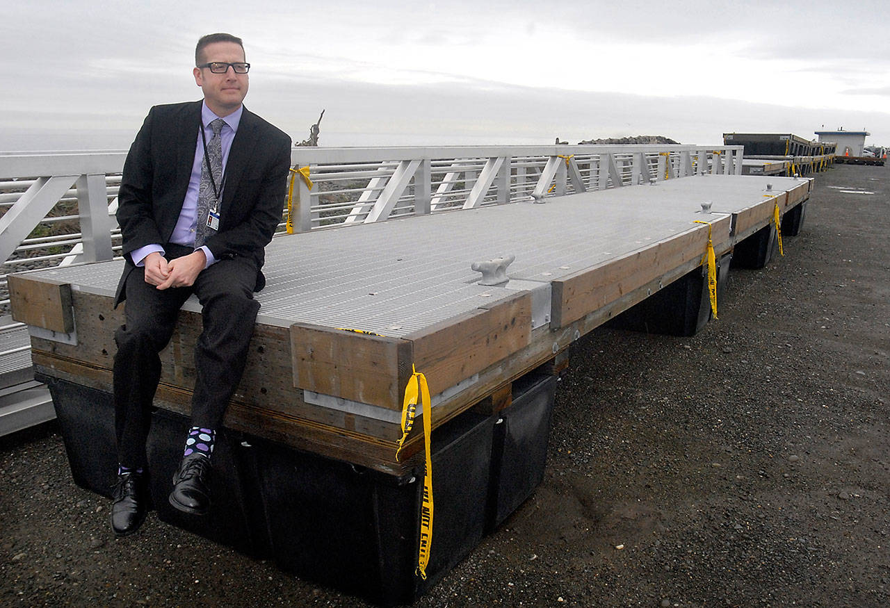 Port Angeles Parks and Recreation Department Director Corey Delikat sits on a floating dock section expected to be installed at Port Angeles City Pier this spring. New dock sections and a new gangway are currently being stored on Ediz Hook. (Keith Thorpe/Peninsula Daily News)