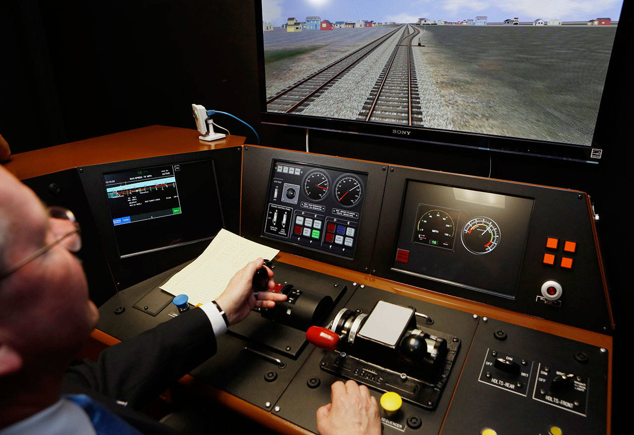 In a Feb. 20, 2014, file photo, Metrolink Director of Operations R.T. McCarthy demonstrates Metrolink’s implementation of Positive Train Control, (PTC) at the Metrolink Locomotive and Cab Car Simulators training facility in Los Angeles’ Union Station. (The Associated Press File)