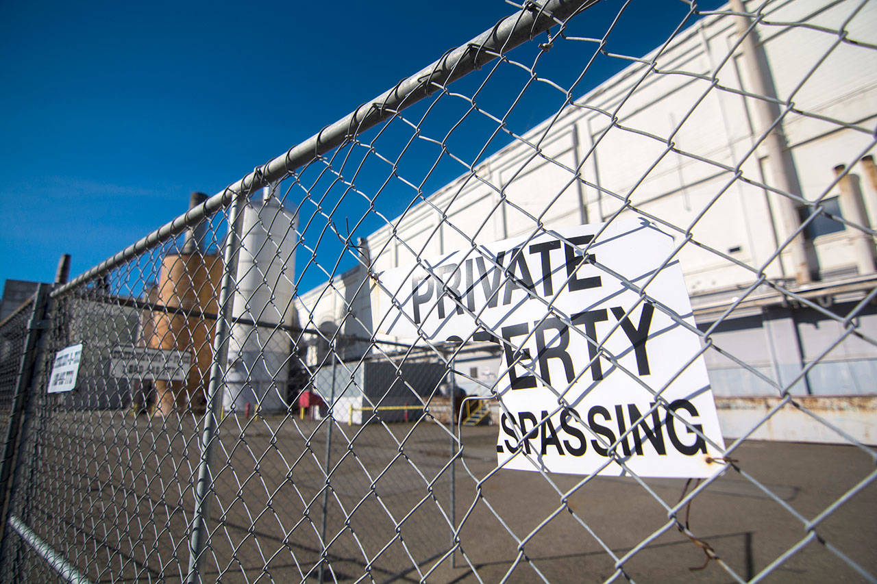 A tattered “no trespassing” sign hangs on the fence outside McKinley Paper’s mill in Port Angeles on Monday. (Jesse Major/Peninsula Daily News)