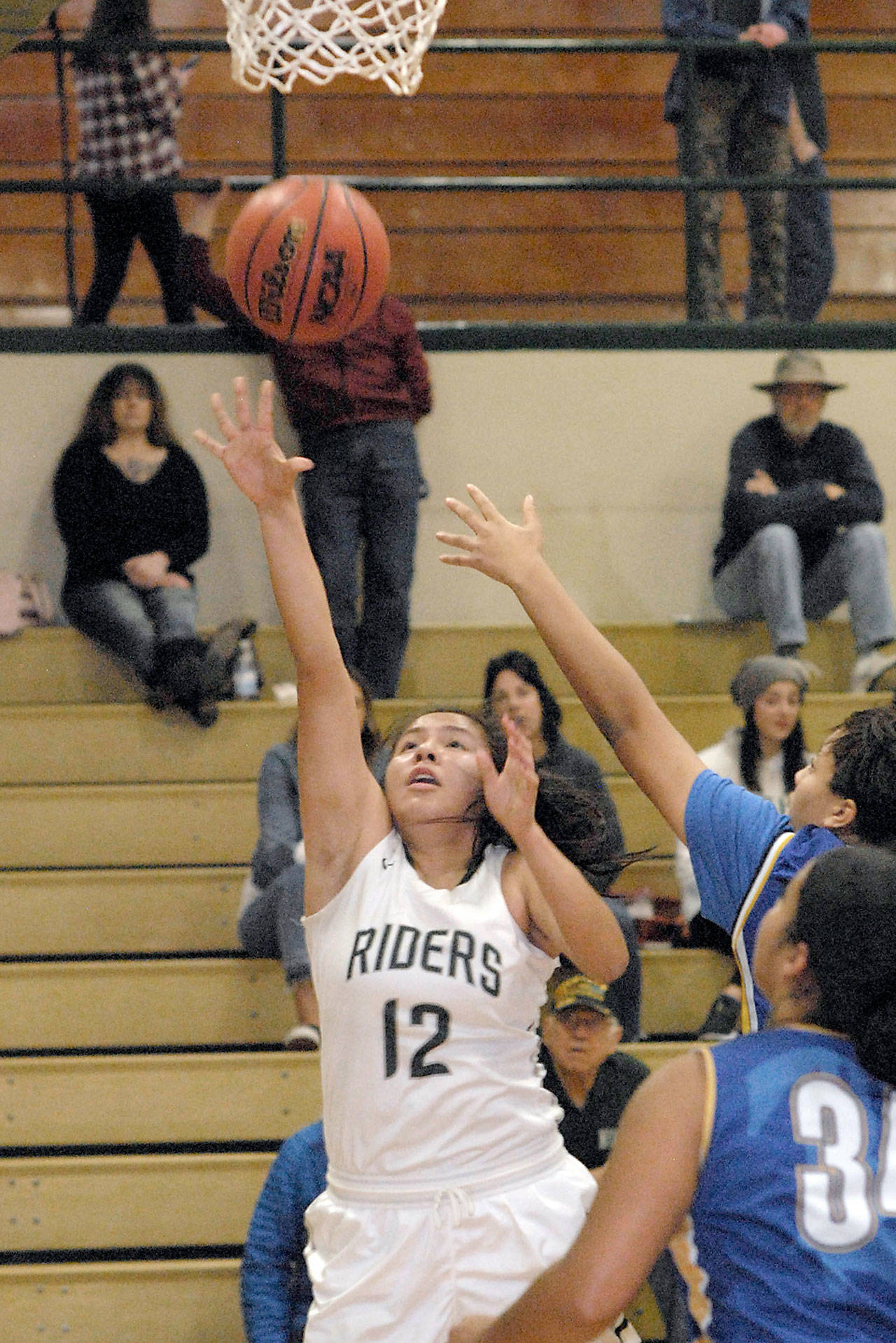 Keith Thorpe/Peninsula Daily News Cheyenne Wheeler of Port Angeles makes a layup as Bremerton’s Brandalynn Gehring and Aida Anderson, front defend on Jan. 3, at Port Angeles High School.