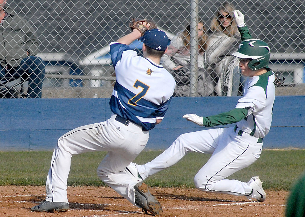 Port Angeles’ Gavin Guerrero, right, slides safely into home as Aberdeen pitcher Jaxson Larson waits for the ball after a wild pitch slipped past catcher Josh Germeaux in the second inning on Saturday at Port Angeles Civic Field. Keith Thorpe/Peninsula Daily News