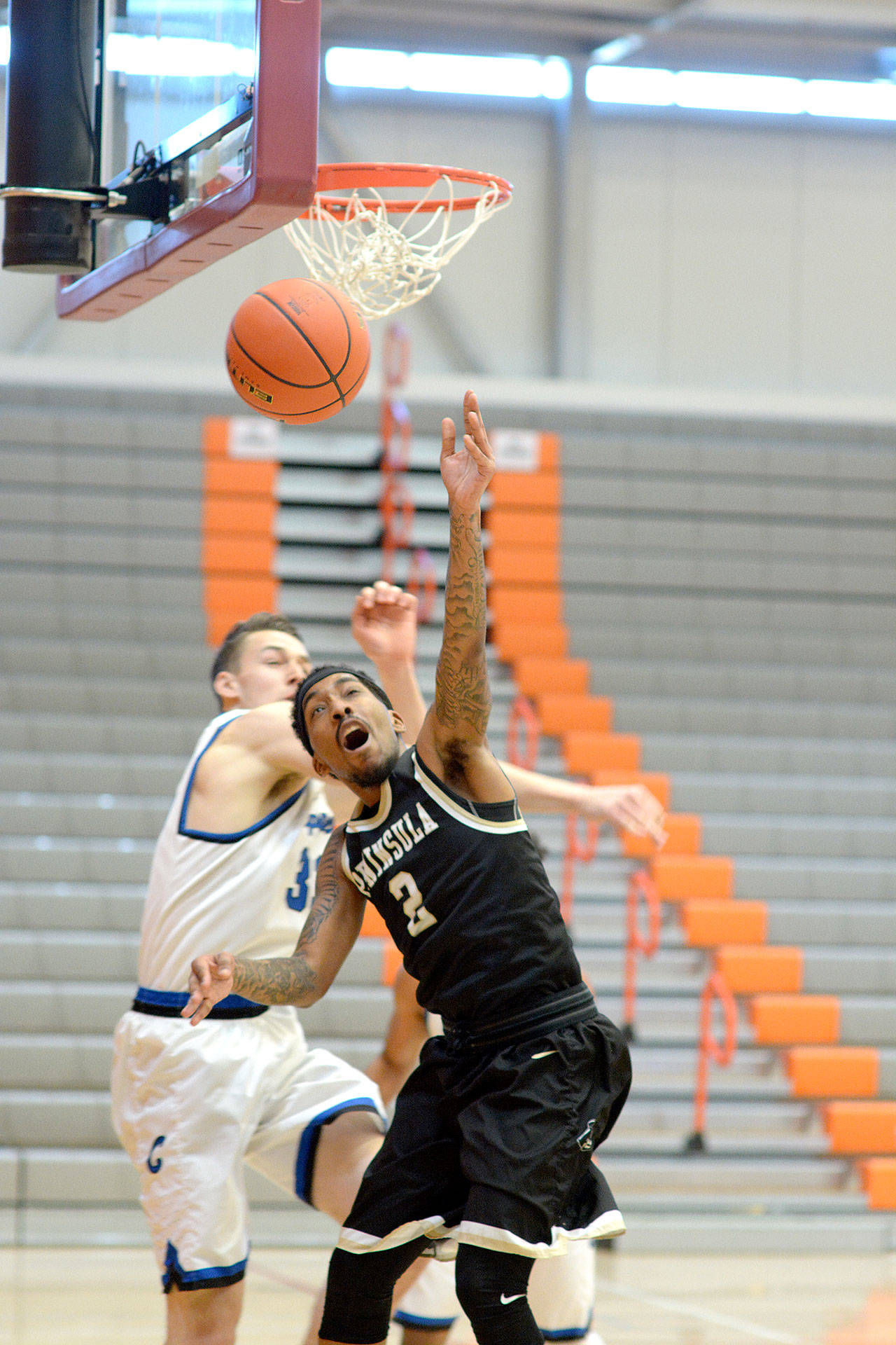 Peninsula College’s Cameron Burton battles for a loose ball against South Puget Sound in the NWAC Elite 8 held at Everett College on Sunday. Peninsula won 69-59 to qualify for the Final Four of the NWAC. (Rick Ross)
