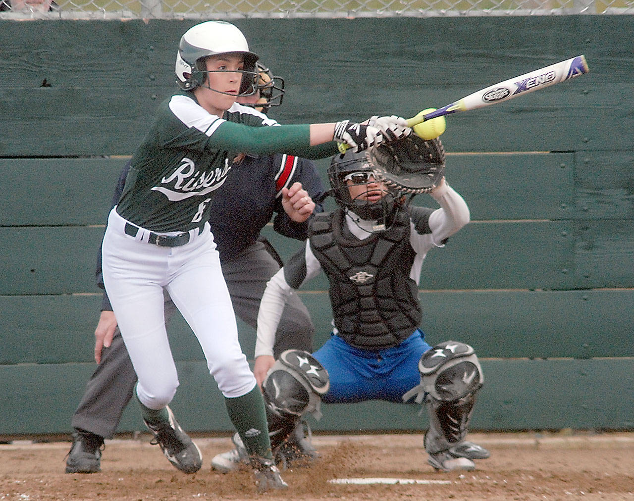 Keith Thorpe/Peninsula Daily News Port Angeles’ Ella Holland bats in the first inning as Olympic catcher Moe Morris receives the delivery on Friday at Dry Creek School in Port Angeles.