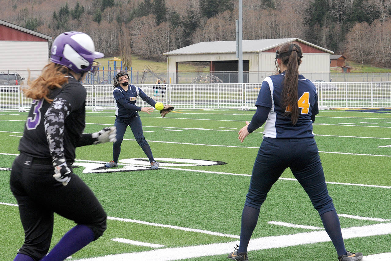 Lonnie Archibald/for Peninsula Daily News Quilcene’s Erin Macedo, left, was safe at first as Forks second baseman Myah Rondeau throws to first baseman Natalie Lausche during the first softball game played on the artificial turf at Spartan Stadium in Forks.