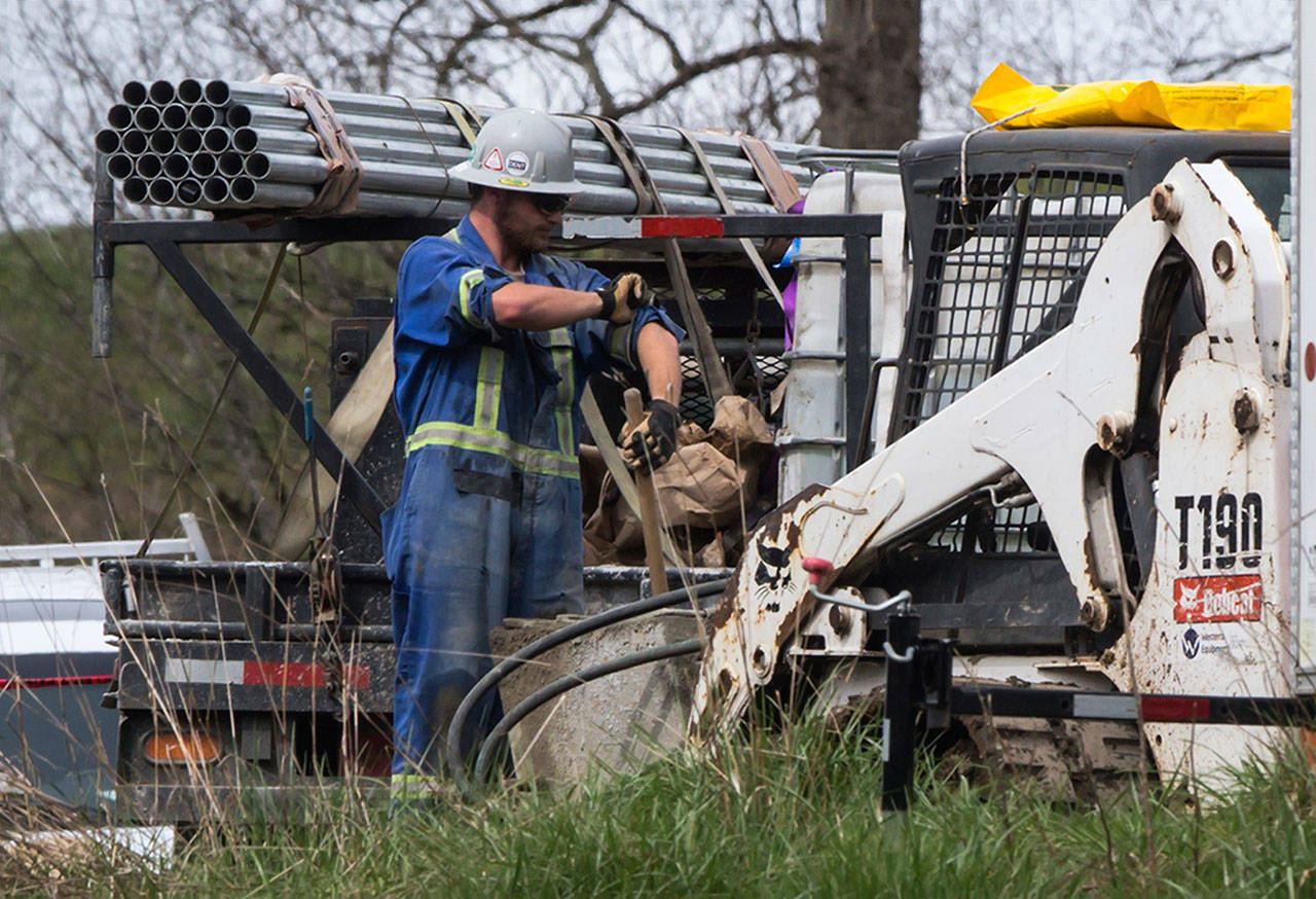 An employee rolls up his sleeves as work continues at Kinder Morgan’s facility in preparation for the expansion of the Trans Mountain Pipeline in Burnaby, B.C., on April 9. (Darryl Dyck/The Canadian Press via AP)