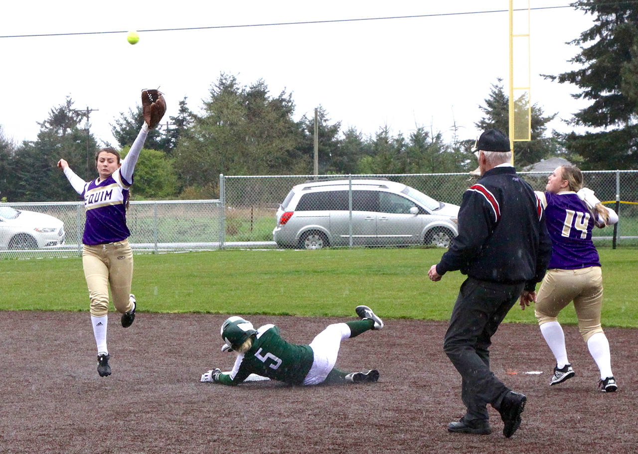 Sequim’s Bobbi Sparks, left, is unable to catch a high throw to second base on a steal attempt by Port Angeles’ Natalie Steinman (5). Steinman slid past the base on the slippery artificial turf infield and Sequim’s Shelby Jones (14) caught the overthrown ball and tagged out Steinman. Dave Logan/for Peninsula Daily News