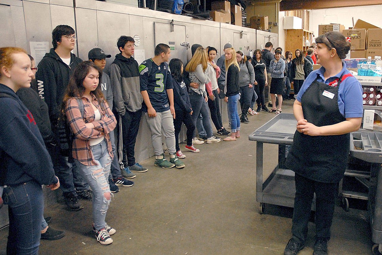 Valerie Sandberg, a food service worker for Sodexo, right, keeps watch on a group of students in the Port Angeles High School kitchen after they were evacuated from the cafeteria during an active shooter drill on Friday. (Keith Thorpe/Peninsula Daily News)