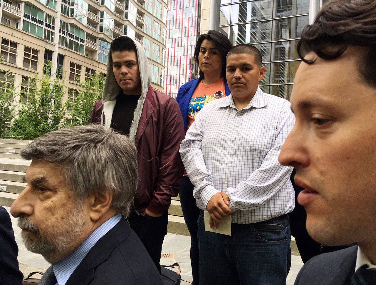 Daniel Ramirez Medina, center right, listens as two of his lawyers, Mark Rosenbaum, left, and Nathaniel Bach, right, address reporters following a hearing in U.S. District Court in Seattle on Tuesday. (Gene Johnson/The Associated Press)
