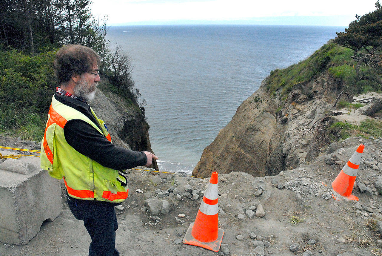 Assistant Clallam County engineer Joe Donisi looks over an eroded section of bluff caused by a damaged drainage culvert under West Bluff Road in The Bluffs neighborhood east of Port Angeles on Thursday. (Keith Thorpe/Peninsula Daily News)
