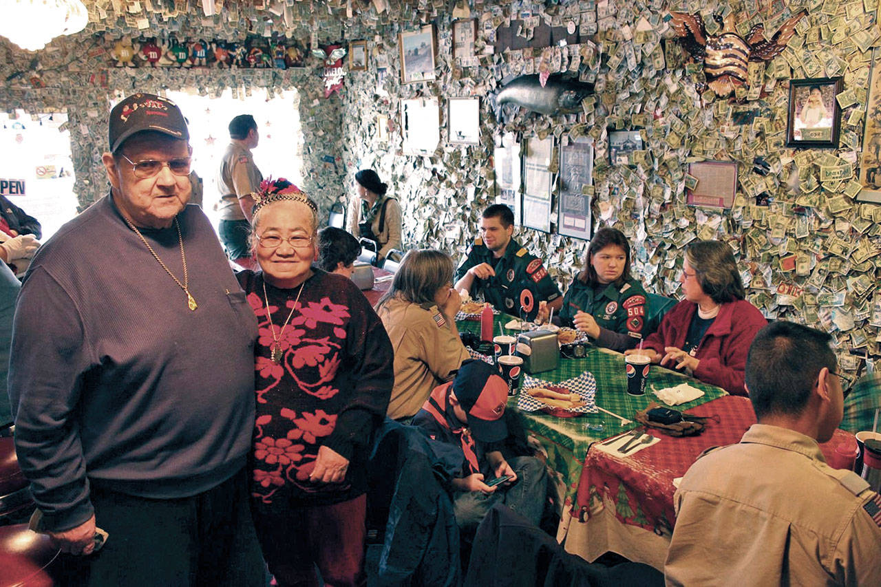 Carl and Miyo (“Mickey”) Schmidt threw in a batch of Smitty’s famous burgers for the volunteer workers as they collected a cache of dollar bills put up on Fat Smitty’s walls in January 2012. (Olympic Peninsula News Group)