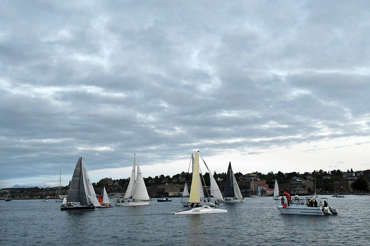 And they’re off! The Race Committee Boat signals the start of the 2018 R2AK in Port Townsend Bay with a blast of its horn at 5 a.m. Thursday. The fleet has to round the committee boat and Point Hudson before entering the Strait of Juan de Fuca. (Jeannie McMacken/Peninsula Daily News)