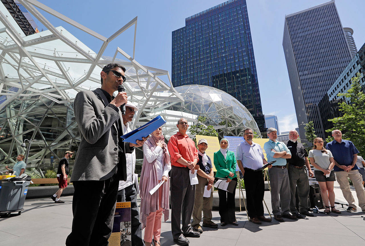 Shankar Narayan, legislative director of the ACLU of Washington, left, speaks at a news conference outside Amazon headquarters Monday in Seattle. (Elaine Thompson/The Associated Press)