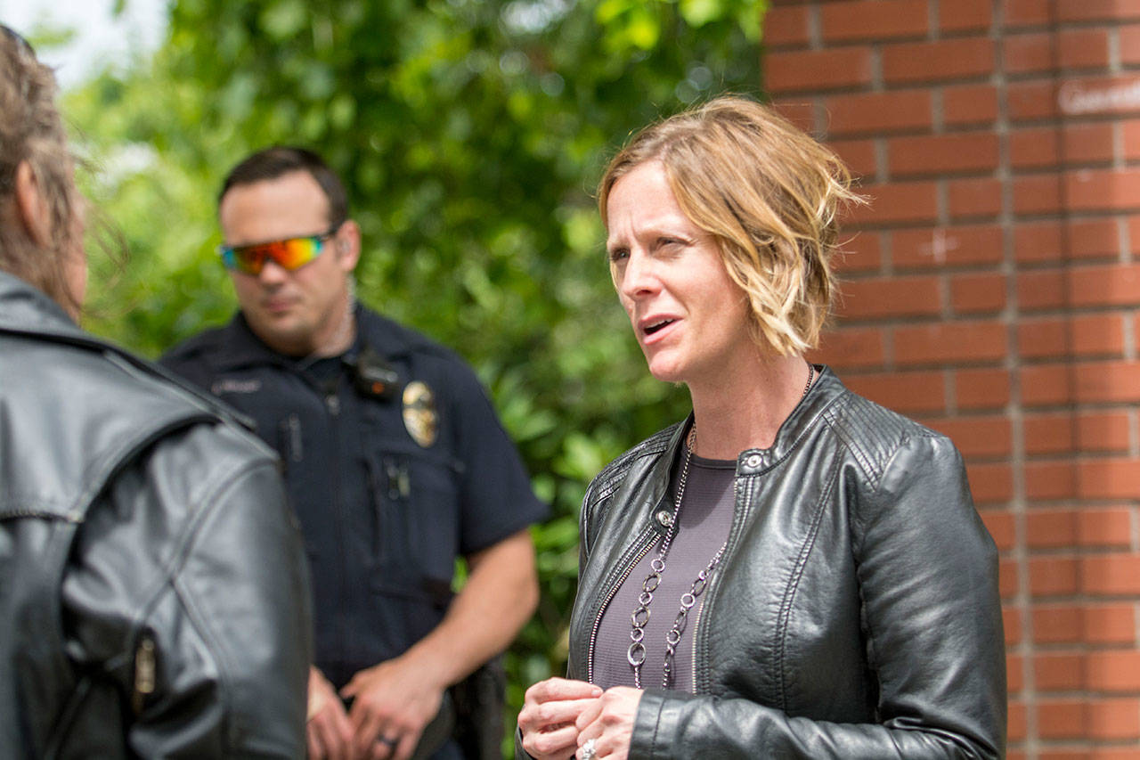 Amy Miller, who heads Volunteers In Medicine of the Olympics’ Rediscovery Program in partnership with the Port Angeles Police Department, talks with a woman at Veterans Memorial Park in Port Angeles about services that may be available. (Jesse Major/Peninsula Daily News)