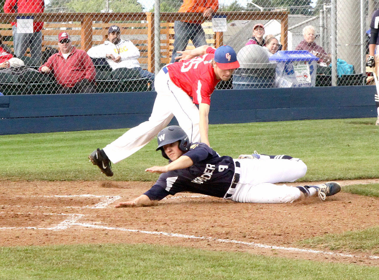 Wilder’s Matt Bainbridge is tagged out by Centerfield’s Randy Yeakley after getting caught in a rundown between third base and home in Wilder’s 8-2 win over the Centerfield Roosters on Saturday. (Dave Logan/for Peninsula Daily News)