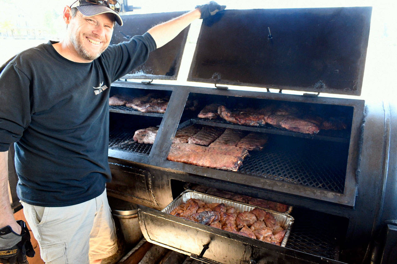 Mike Harbin of Mo-Chilli BBQ, originally from Round Rock, Texas and now based in Port Townsend, is a fan favorite food vendor at the Old School 4th of July. Harbin started cooking his Texas-style BBQ brisket, ribs, chicken, pulled pork and sausage in his food truck Tuesday at the Parade Grounds at Fort Worden. (Jeannie McMacken/Peninsula Daily News)