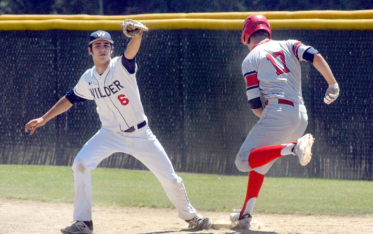 Wilder first baseman Bo Bradow, left, gets the ball ahead ofl Skagit batter Tyler Henry for the third out in the top of the fourth inning during the first game of a double header on Saturday at Port Angeles Volunteer Field. (Keith Thorpe/Peninsula Daily News)