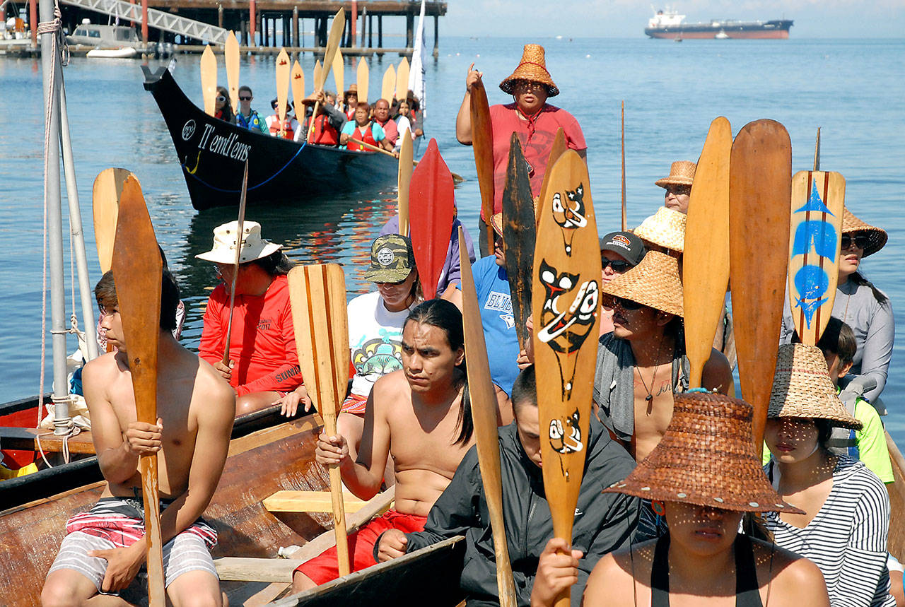 Keltsmaht Thomas of Ahousaht First Nations on Vancouver Island, standing at rear, asks for permission to come ashore at Hollywood Beach in Port Angeles on Friday as a canoe belonging to Klahoose First Nation approaches behind him. (Keith Thorpe/Peninsula Daily News)