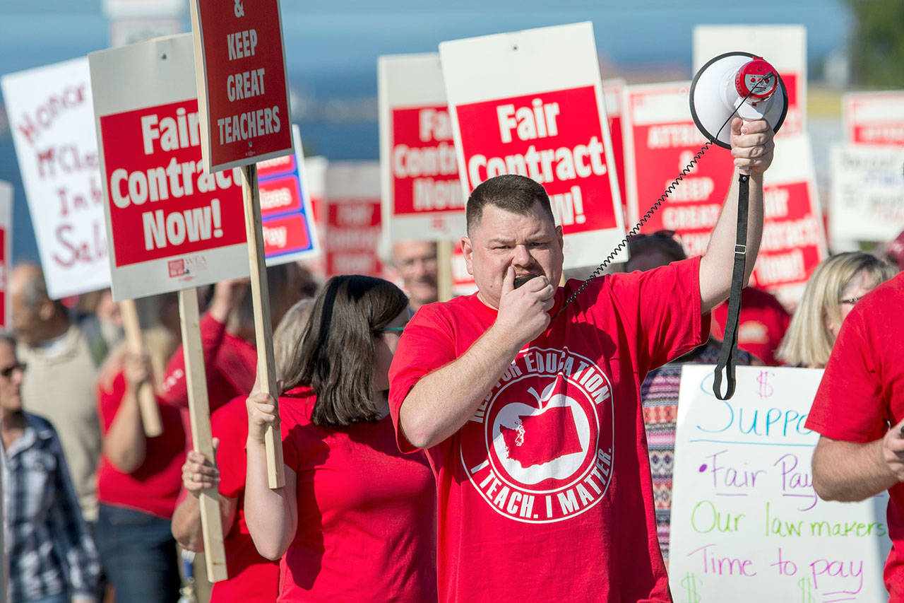 Port Angeles Education Assocation President Eric Pickens leads hundreds of teachers and their supporters as they march toward the Port Angeles School District Central Services building on Thursday. (Jesse Major/Peninsula Daily News)