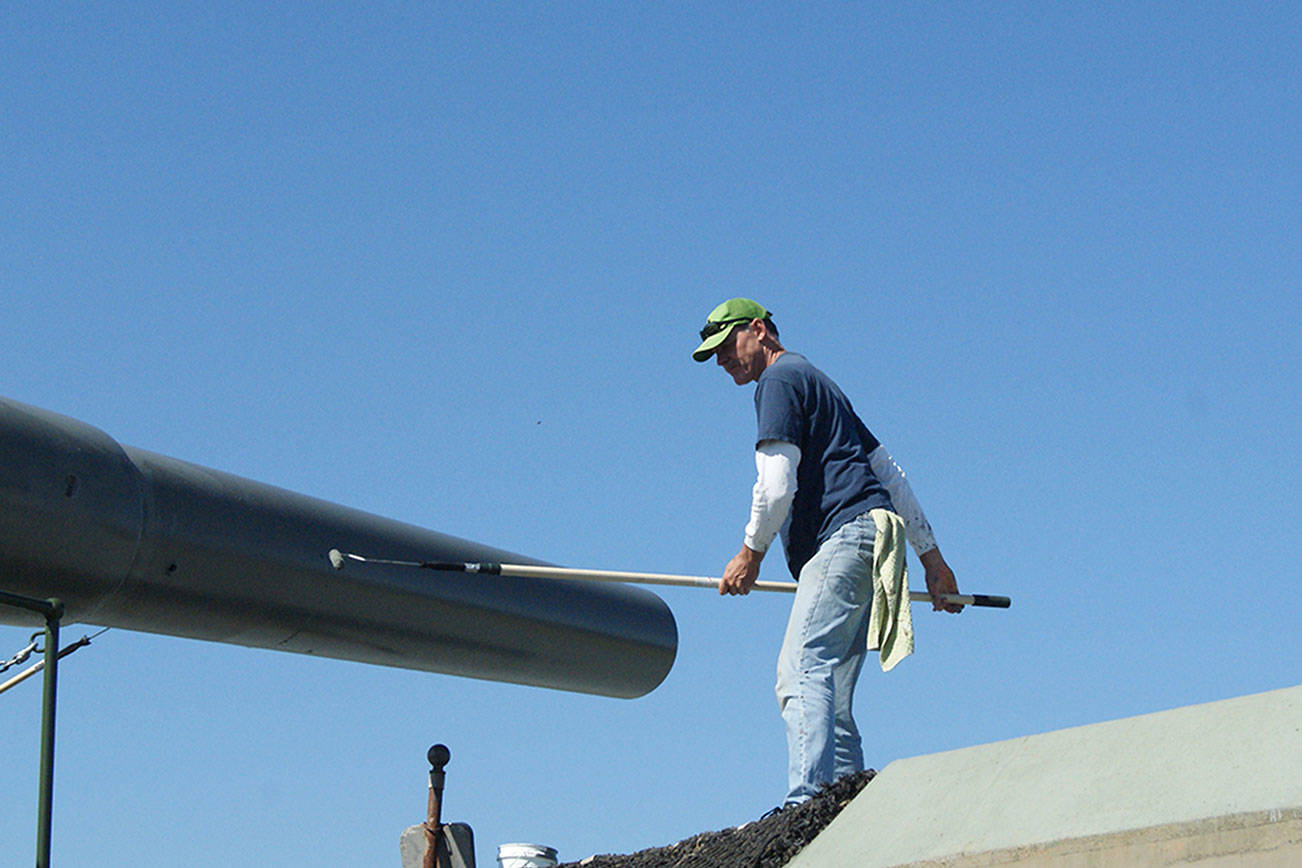 John White of Freeland works to paint the “Big Guns” at Fort Casey. It was a good day to paint, with the sunshine and fresh air, he said. (Maria Matson/Whidbey News Group)