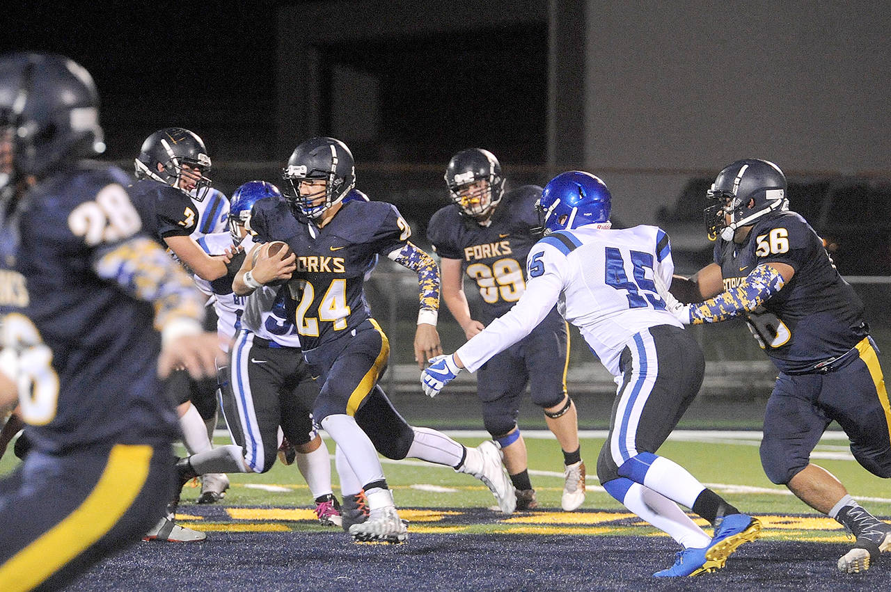 Lonnie Archibald/for Peninsula Daily News Forks’ Colby Demorest runs with the ball during a game against North Mason last season. Also in on the action for Forks are returners from left, Brett Moody, Caleb Peters and Eden Cisneros.
