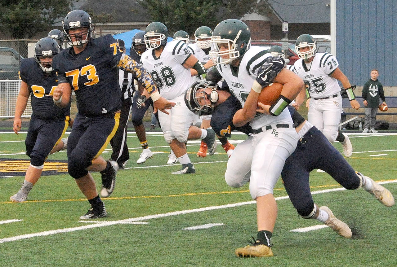 Lonnie Archibald/for Peninsula Daily News Forks’ Brett Moody brings down Port Angeles quarterback Brenden Roloson-Hines, with ball, as Spartans Tristen Pisani (34) and Luke Dahlgren (73) close in.