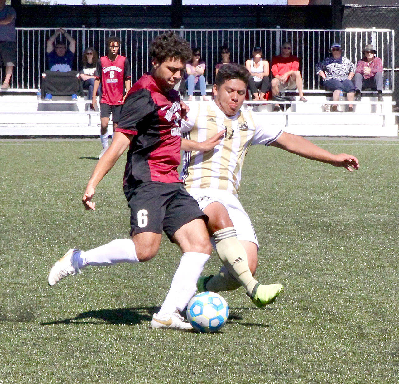 Peninsula College’s Manny Lopez (17) fights for the ball against Josh Greer (6) from North Idaho in a match at Wally Sigmar Field on Sunday. (Dave Logan/for Peninsula Daily News)