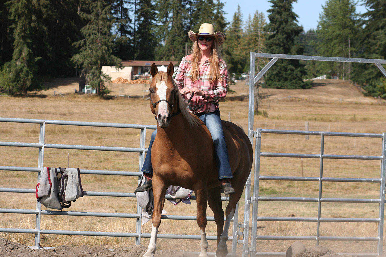 Born out of a desire to share the beauty and serenity of her trail rides through the forest adjacent to their Blue Meadow Farm, Rusty Moroz, riding Kodak, and her husband, Duke Moroz, decided to offer guided trail rides through the forest and riding lessons for beginners, calling it Rustic Riding. (Karen Griffiths/for Peninsula Daily News)