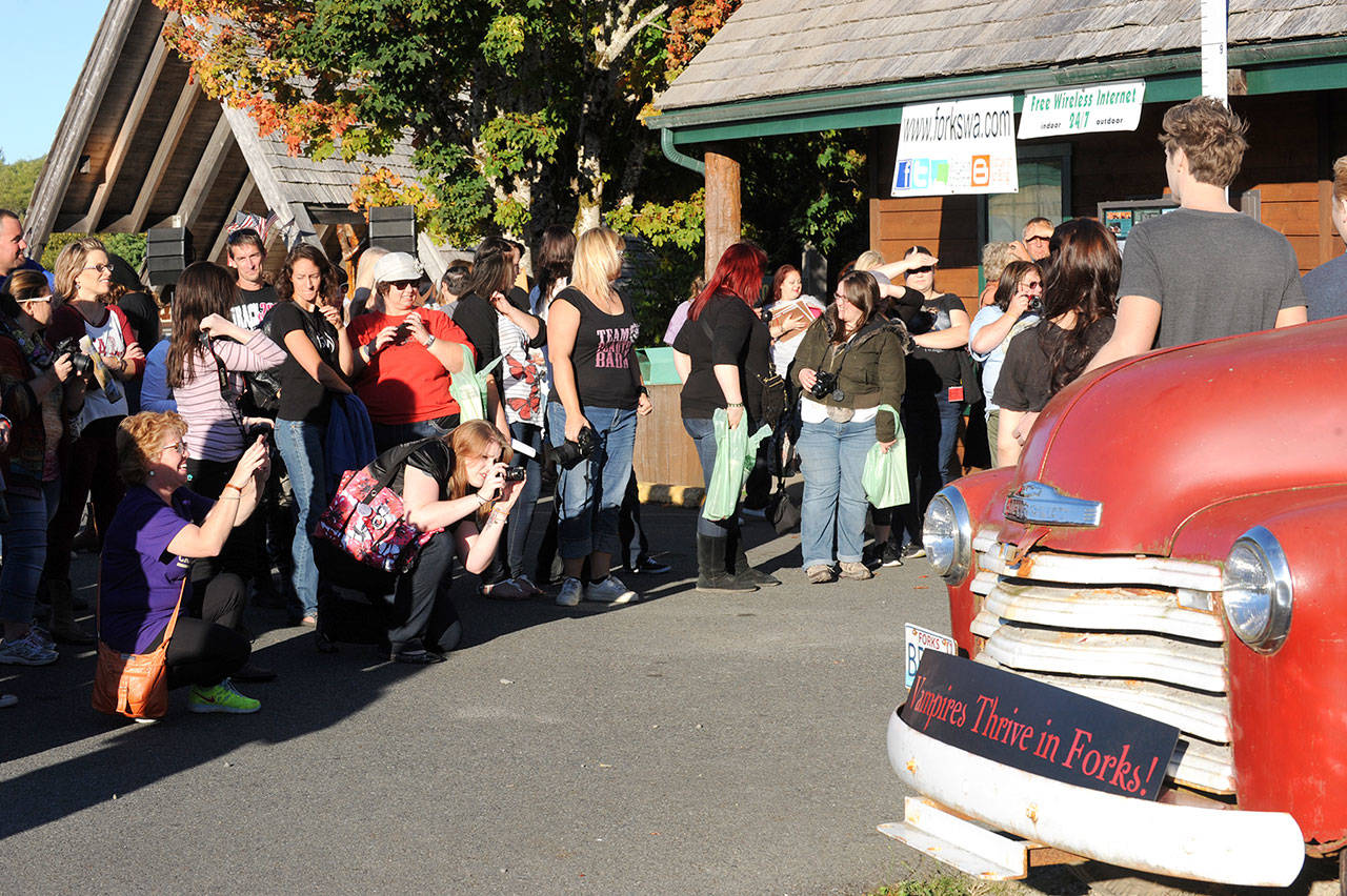 Visitors at the Forks visitors center photograph Twilight look-alikes along with family and friends in front of Bella’s pickup. (Lonnie Archibald/for Peninsula Daily News)