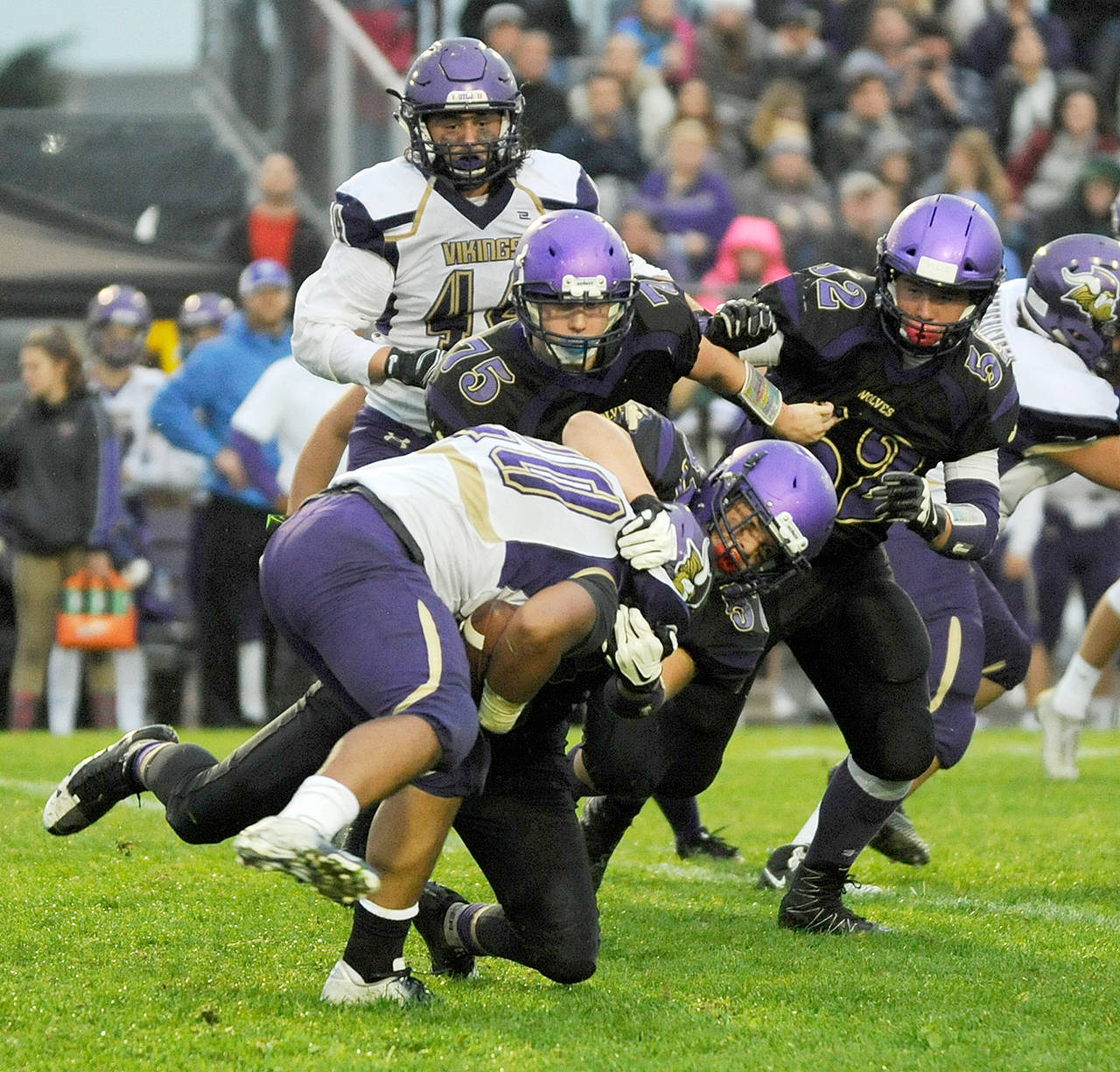 Michael Dashiell/Olympic Peninsula News Group Sequim’s Austin Henning hauls down North Kitsap’s Isaiah Kahana while backed up by teammates Austin Newton (75) and Johnnie Young.