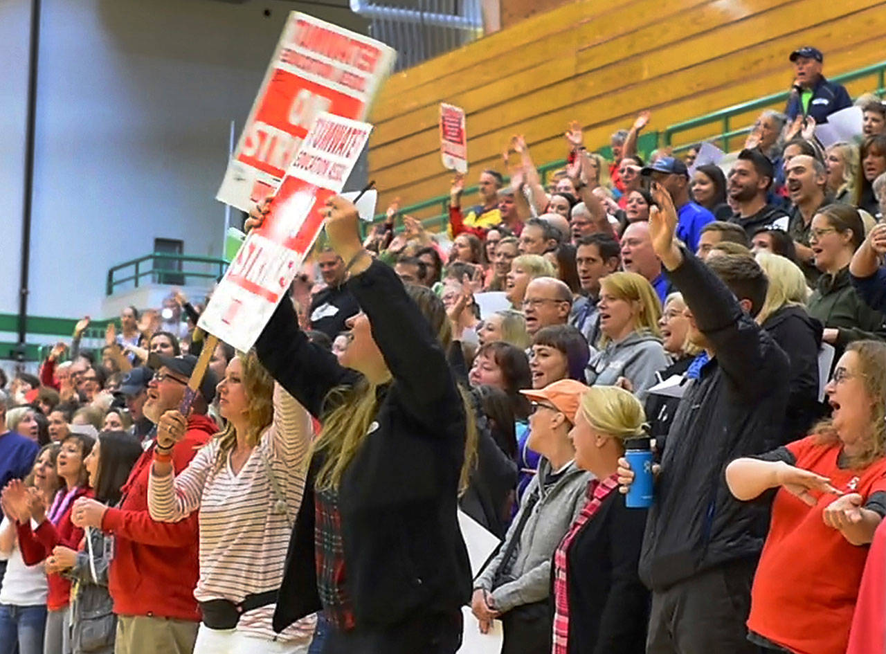 Meeting in the Tumwater High School gymnasium Monday, Black Hills High School teacher Matt Bell leads a jubilant group of his fellow educators in the Neil Diamond song “Sweet Caroline” as they celebrate a 98 percent ratification of their new two-year contract with the district. (Steve Bloom/The Olympian via AP)
