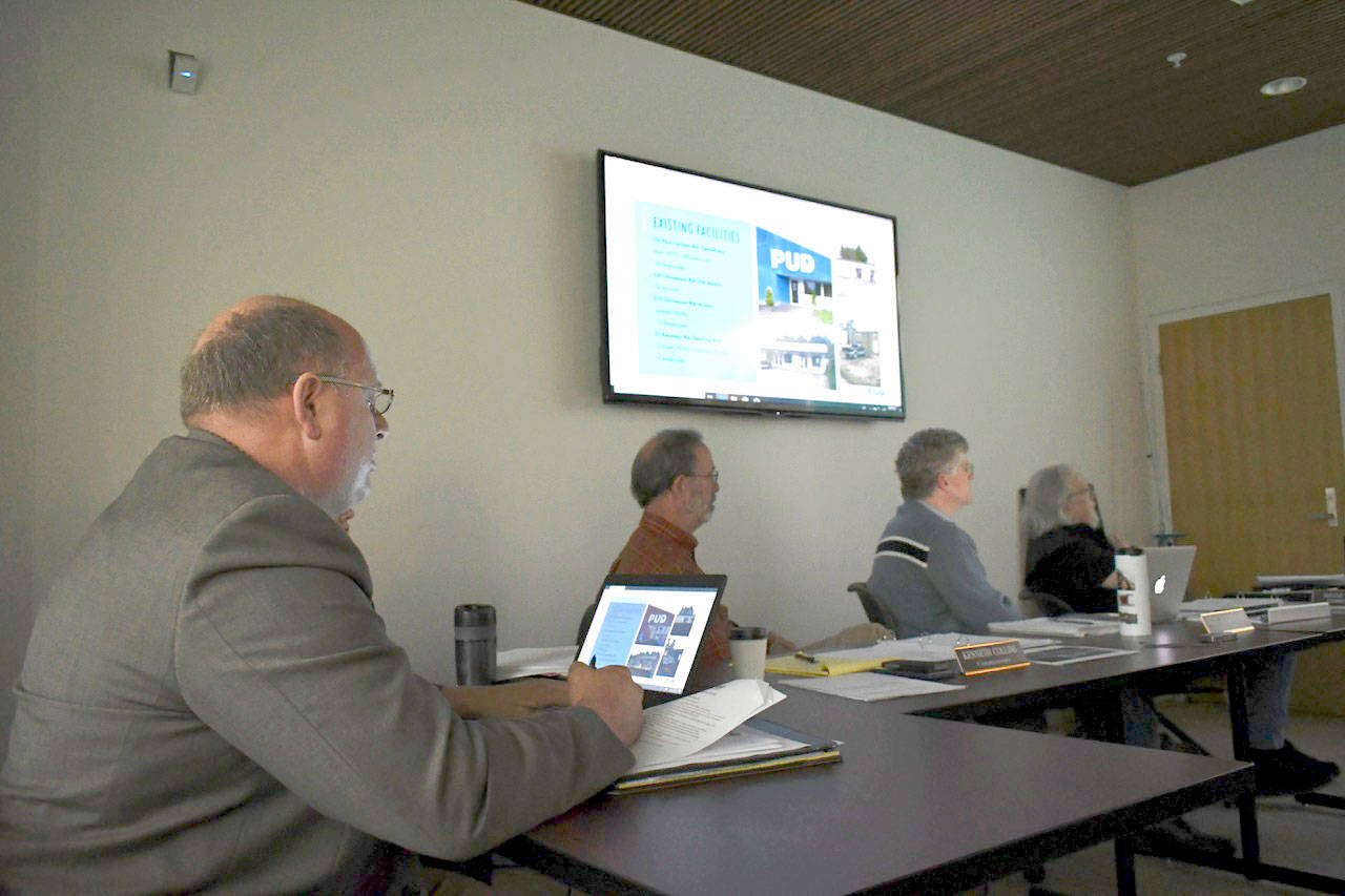 Jefferson County PUD General Manager Larry Dunbar, left, makes a presentation about the proposed expansion of the utility’s Port Townsend headquarters during a meeting Tuesday evening. Commissioners Kenneth Collins, Jeff Randall and Wayne King focus in on the details of the facility remodel and expansion. (Jeannie McMacken/Peninsula Daily News)