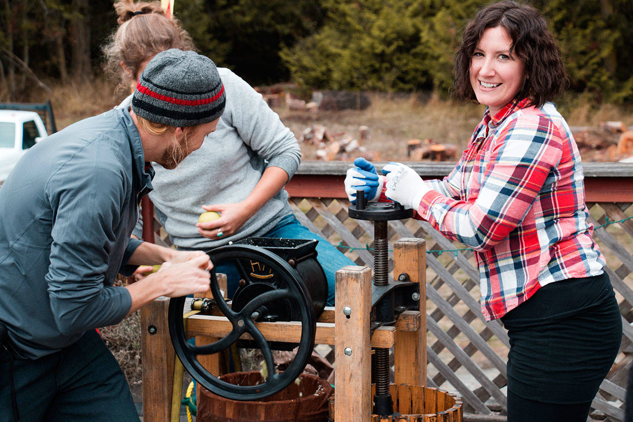 Cider Saloon attendees take part in traditional apple pressing at the 2017 Olympic Peninsula Apple Cider Festival in Port Townsend. (Jack Kingsley)