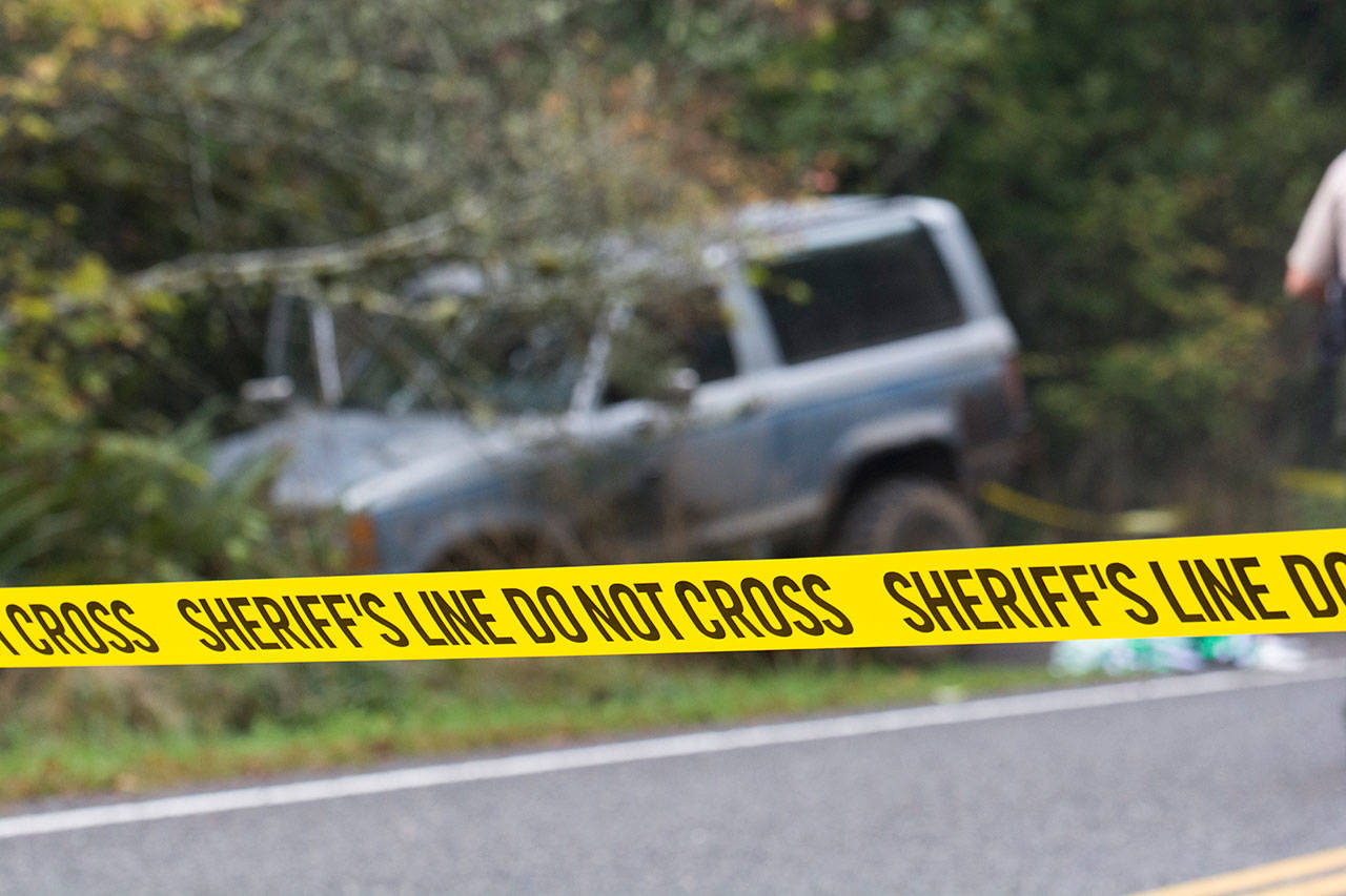 A Ford Bronco sits in a ditch on Whiskey Creek Beach Road west of Joyce after a shooting early Monday evening. (Jesse Major/Peninsula Daily News)