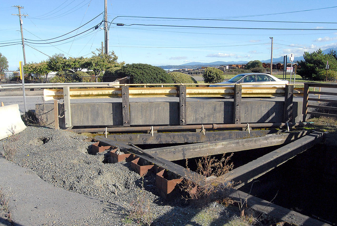 A car crosses a short bridge spanning a canal that connects the lagoon near the McKinley Paper mill in Port Angeles with the waters of Port Angeles Harbor. The city plans to repair the span beginning in November. (Keith Thorpe/Peninsula Daily News)