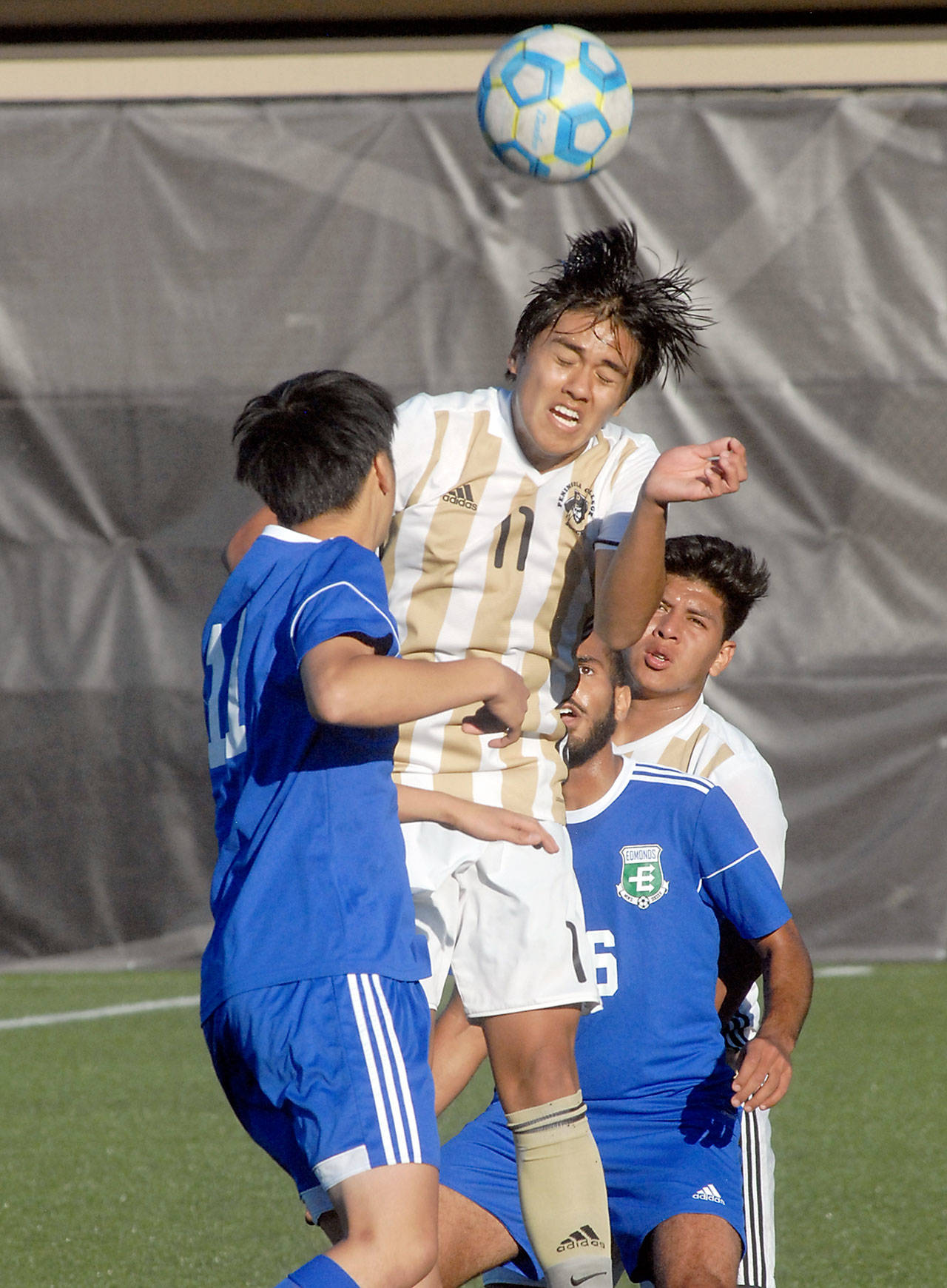 Keith Thorpe/Peninsula Daily News Peninsula’s Calvin Aguirre, center, takes the header surrounded by Edmonds’ Masahiro Ichikawa, left, and Rafaiel Dawood on Wednesday in Port Angeles. Backing the play was Peninsula’s Manny Lopez, right.