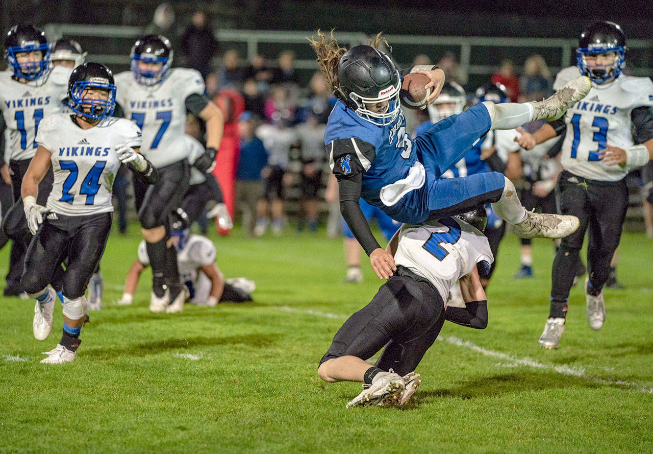 Steve Mullensky/for Peninsula Daily News Chimacum’s Cole Dotson is upended by Bellevue Christian’s Trent Paulson but not before gaining a first down during the Cowboys’ homecoming game on Friday in Memorial Field.