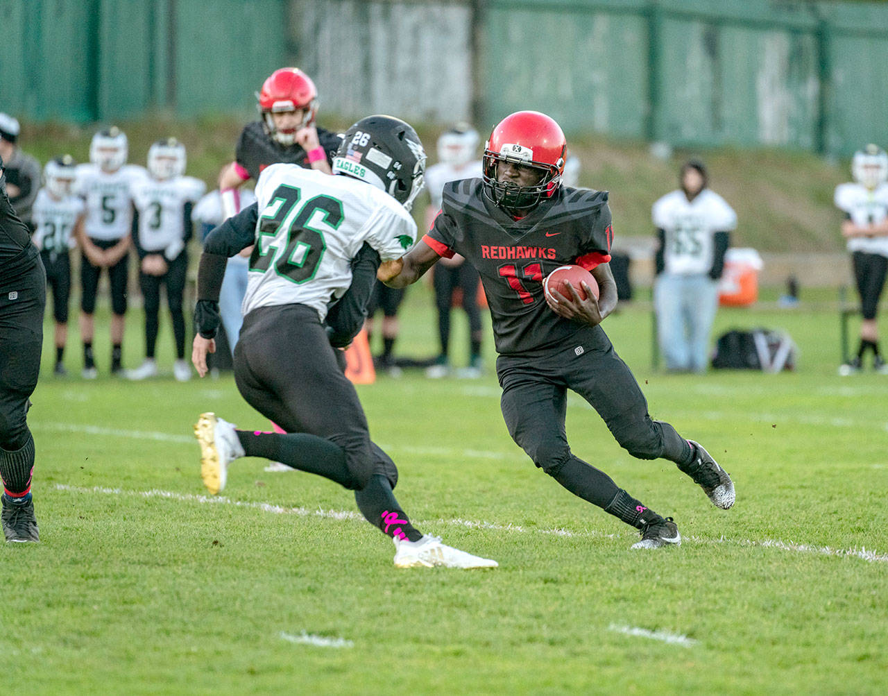 Steve Mullensky/for Peninsula Daily News Port Townsend’s Jerome Reaux Jr. gets around Klahowya’s Luke Stahl and picke up a first down in the first quarter of a game played on Friday in Memorial Field in POrt Townsend.