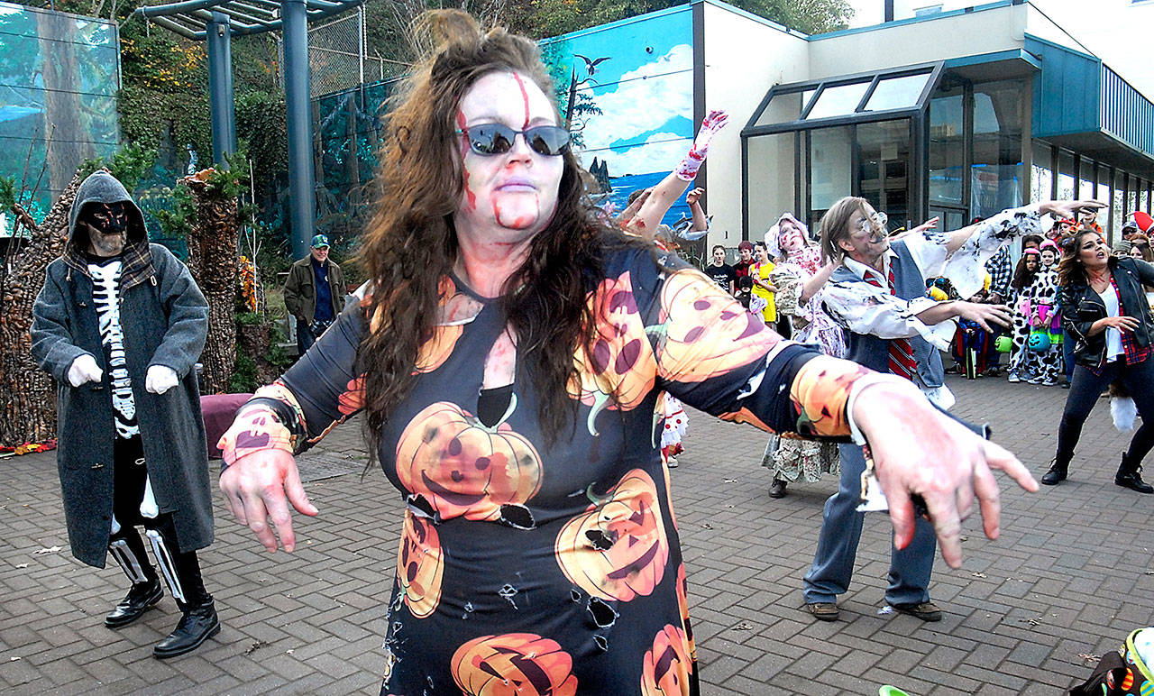 Beckie Tunstall of Port Angeles, center, takes part in a zombie dance with members of Poser Yoga at the Conrad Dyar Memorial Fountain plaza in downtown Port Angeles on Halloween last year. (Keith Thorpe/Peninsula Daily News)