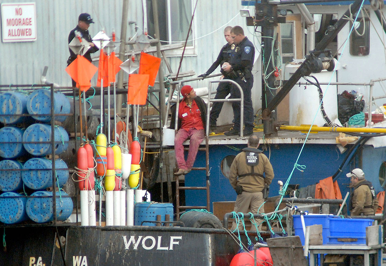 Port Angeles police and U.S. Customs and Border Protection agents are seen with David P. Hoffman aboard the ship Sea Wolf moored near The Landing mall in Port Angeles on Wednesday. (Keith Thorpe/Peninsula Daily News)