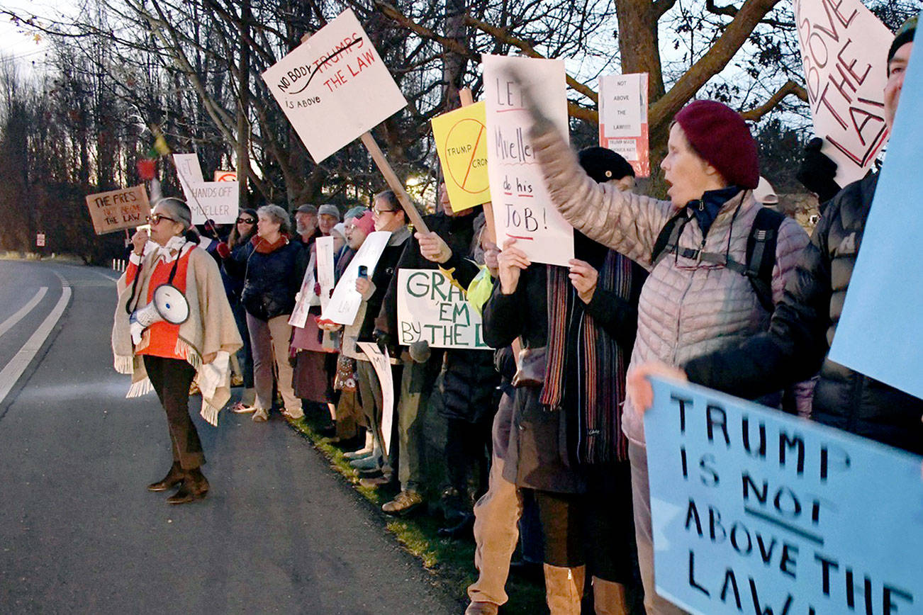 City Councilmember and rally co-organizer Michelle Sandoval encourages a crowd estimated to be around 300 to chant “protect Mueller” and “nobody’s above the law” during a protest Thursday at 5 pm along Sims Way. Rallies like this one were planned across the peninsula. (Jeannie McMacken/ Peninsula Daily News)