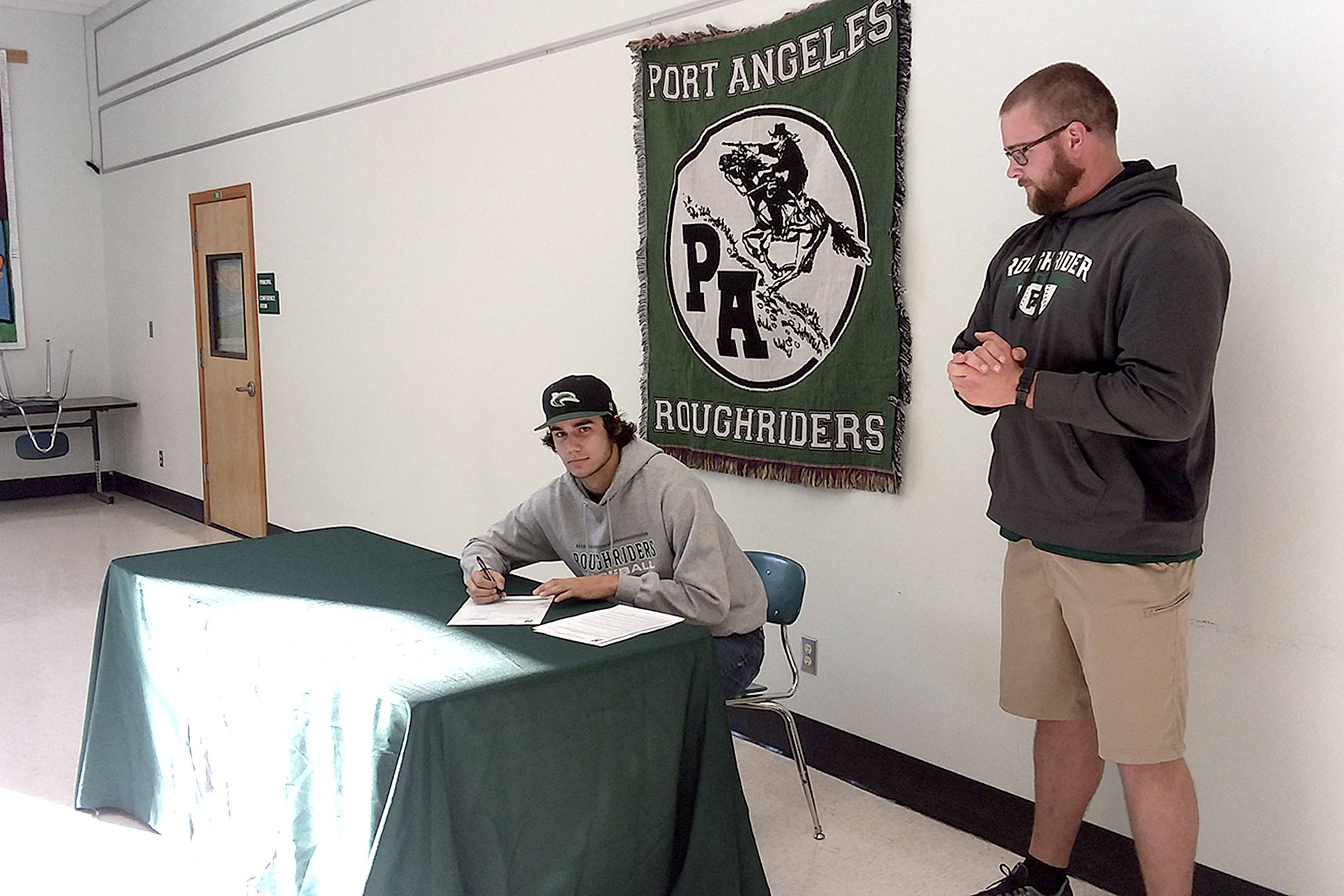 <strong>Pierre LaBossiere</strong>/Peninsula Daily News Port Angeles’ Bo Bradow signs a letter of intent to play baseball for Shoreline College.