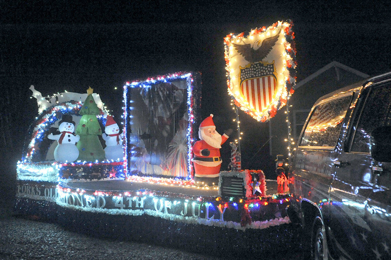A float is illuminated with Christmas lights in Forks’ Twinkle Light Parade last year. (Lonnie Archibald/for Peninsula Daily News)