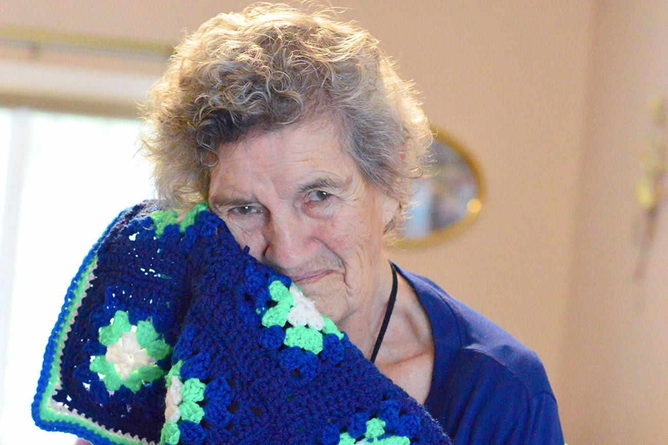 (Diane Urbani de la Paz/for Peninsula Daily News)                                Marie Sewell of Port Townsend makes afghans — such as this one with Seahawks colors — to give away.