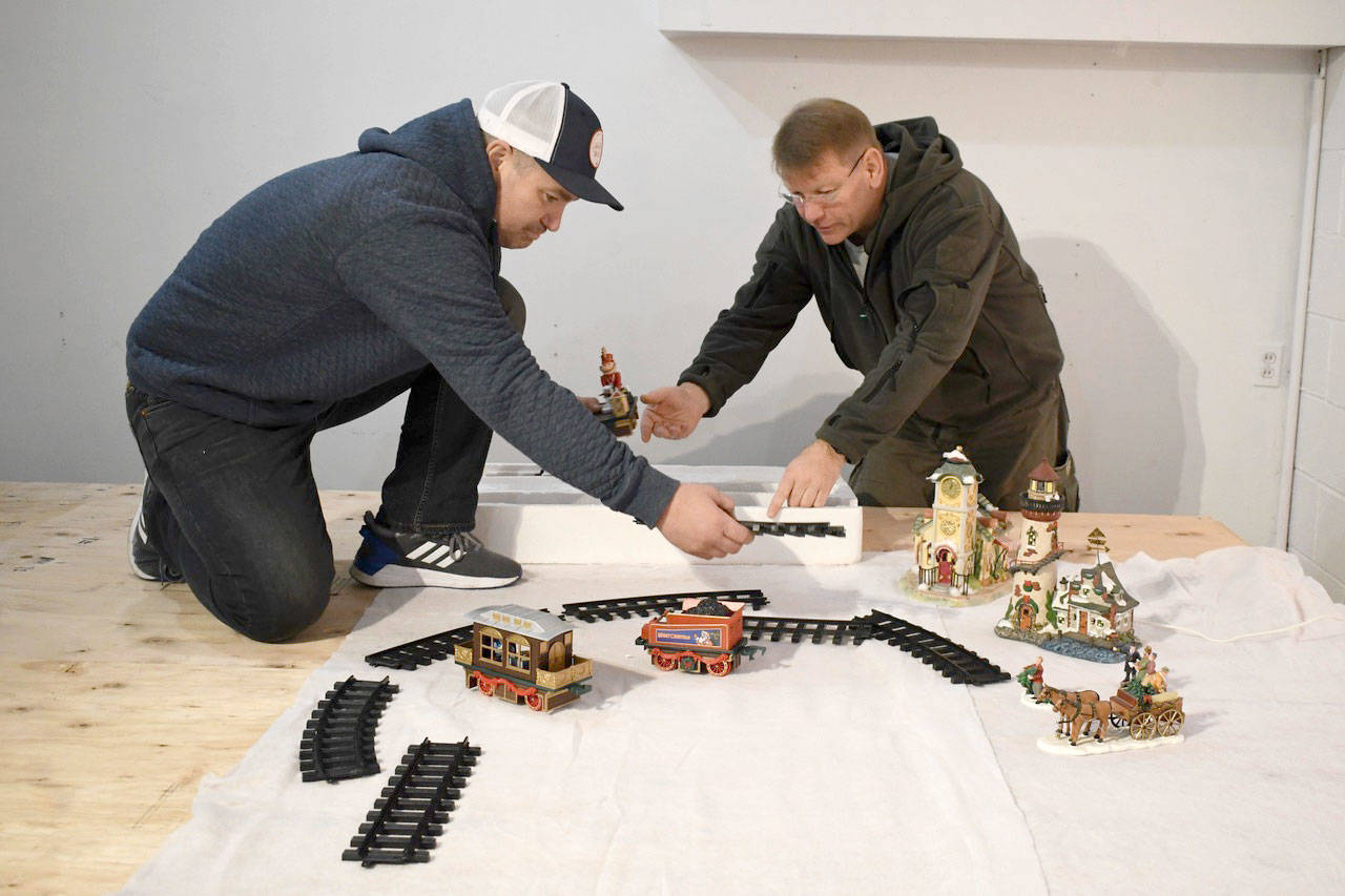 Ted Krysinski, right, and volunteer David Funk begin work on The Winter Window on Washington Street in Port Townsend. (Jeannie McMacken/Peninsula Daily News)