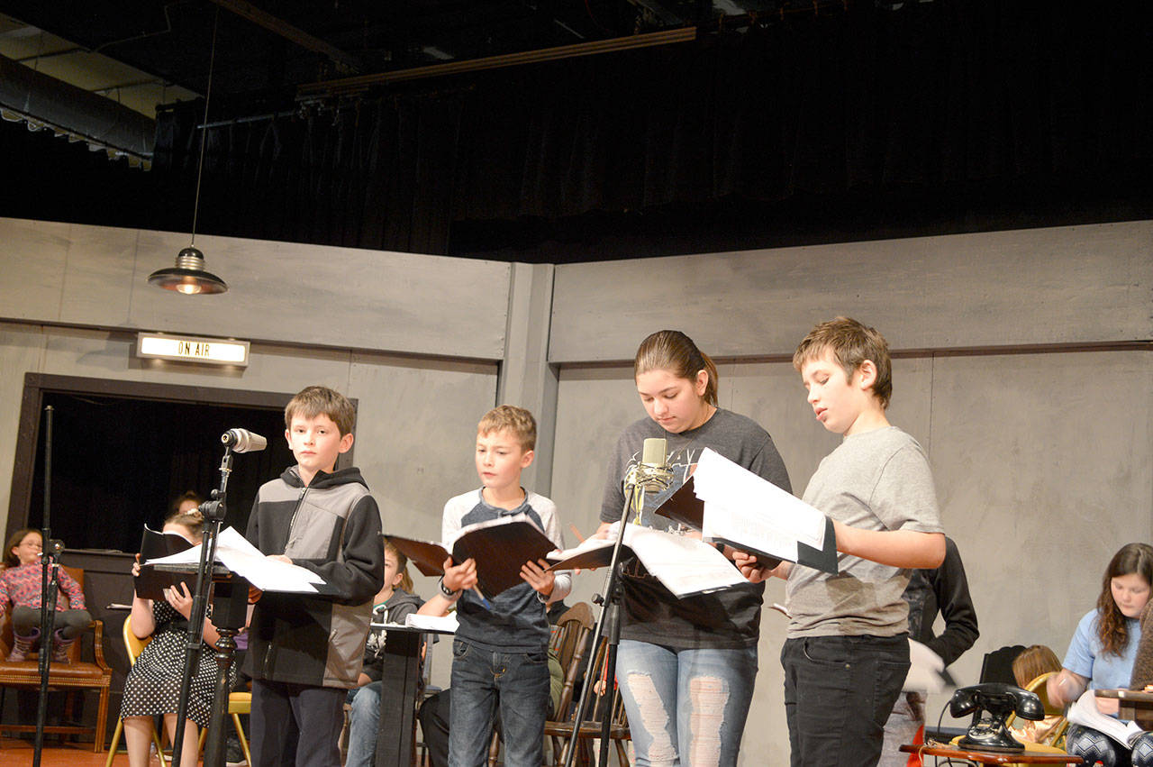 Isaac Rutledge (Ebeneezer Scrooge), Henry Wendel (Peter Cratchit), ShyAnn Welch (Mrs. Cratchit) and Finn Waknitz (Bob Cratchit) rehearse in “Charles Dickens’ A Christmas Carol Radio Show,” slated for this weekend in Port Angeles. (Brandi Welch)